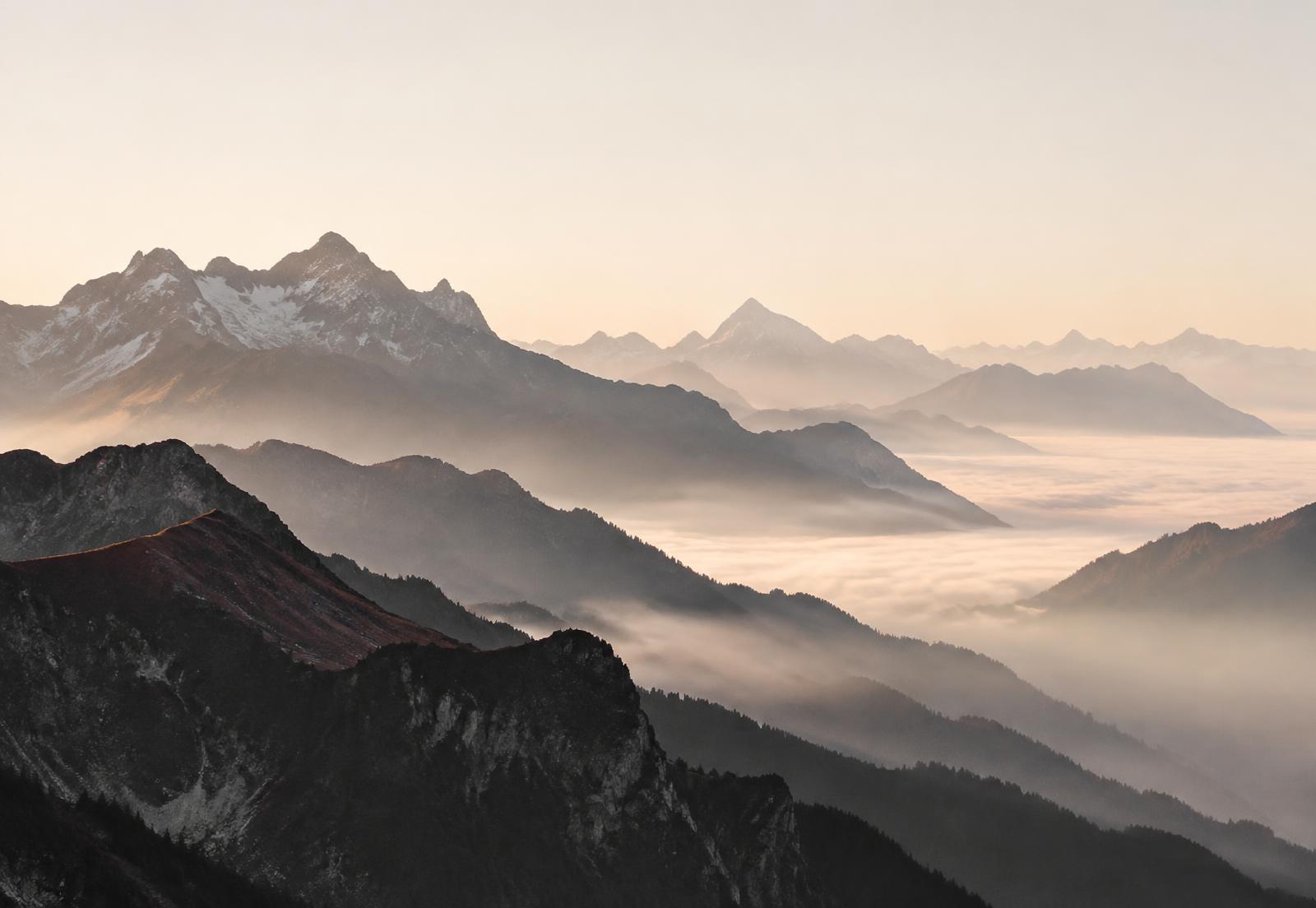 Alpine ridges receding into morning mist
